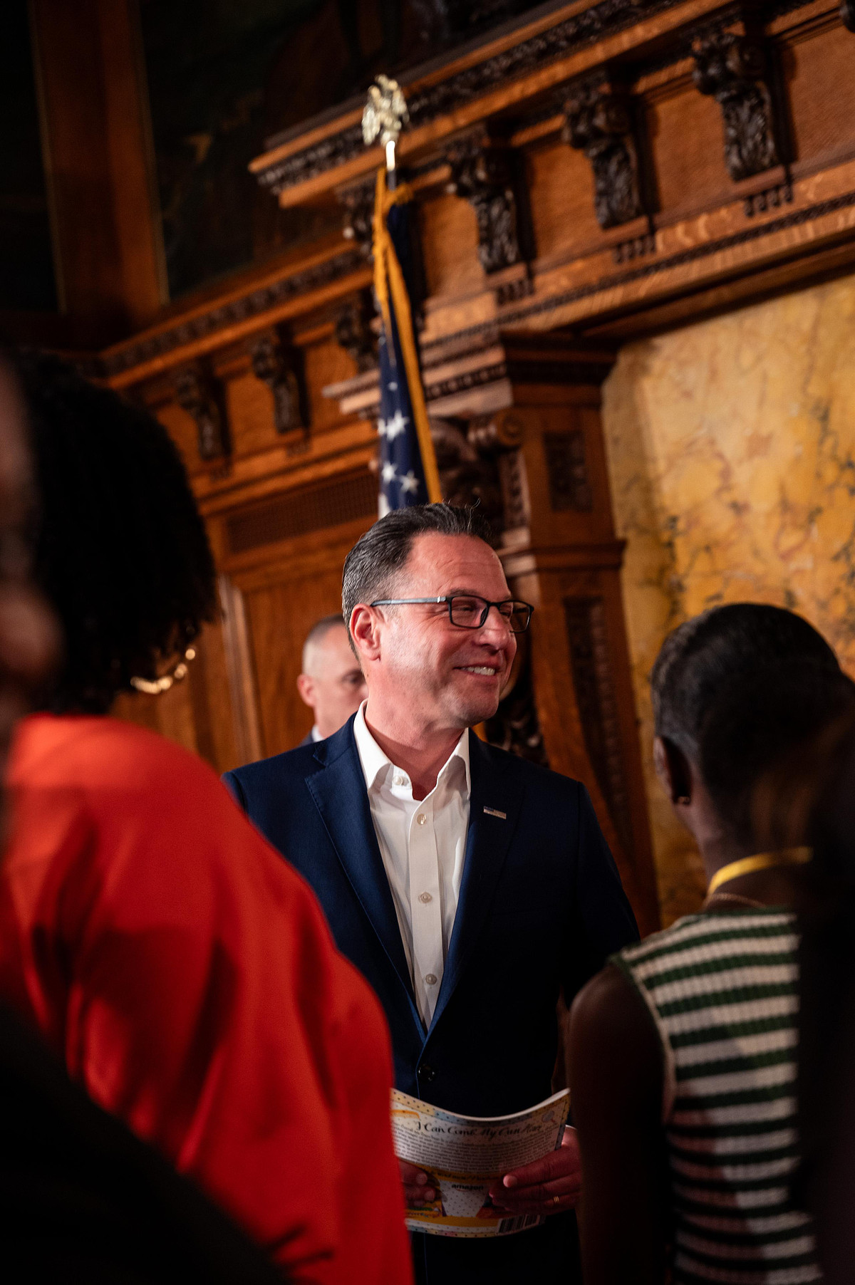 Pennsylvania Governor Josh Shapiro speaking with attendees during the CROWN Act event inside the Capitol, captured candidly between moments